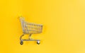 mini shopping cart on yellow background top view. Shopping concept. space for copying text Royalty Free Stock Photo