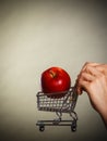 Woman holding shopping cart with apple inside Royalty Free Stock Photo