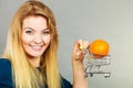 Woman holding shopping cart with orange inside Royalty Free Stock Photo