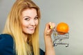 Woman holding shopping cart with orange inside Royalty Free Stock Photo