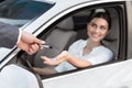 Car dealer giving keys to happy female customer