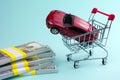 Buying a new car concept. red car money shopping cart Royalty Free Stock Photo