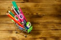 Buying school supplies. Shopping cart with school supplies on wooden background. Back to school concept Royalty Free Stock Photo