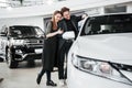 Buying their first car together. High angle view of young car salesman standing at the dealership telling about the Royalty Free Stock Photo
