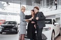 Buying their first car together. High angle view of young car salesman standing at the dealership telling about the Royalty Free Stock Photo