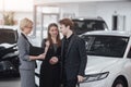 Buying their first car together. High angle view of young car salesman standing at the dealership telling about the Royalty Free Stock Photo