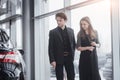 Buying their first car together. High angle view of young car salesman standing at the dealership telling about the Royalty Free Stock Photo