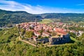 Buzet. Hill town of Buzet surrounded by stone walls in green landscape aerial view