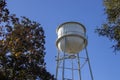 View from below of a municipal water tower against brilliant blue sky background