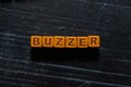 Buzzer on wooden cubes. On table background