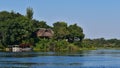 Safari lodge at the riverbank of Okavango River surrounded by dense vegetation with docking boats.
