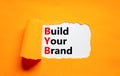 BYB build your brand symbol. Concept words BYB build your brand on white paper on a beautiful orange background. Business and BYB Royalty Free Stock Photo