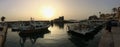 Byblos harbour at dusk, with the silhouettes of fishermen`s boats and the flag of Lebanon on the mediterranee, Lebanon