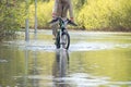 Bycyclist with naked feet try to overcome water Royalty Free Stock Photo