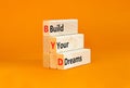 BYD build your dreams symbol. Concept words BYD build your dreams on wooden blocks on a beautiful orange table orange background.