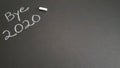 Bye 2020 message with a piece of white chalk on a black background Royalty Free Stock Photo