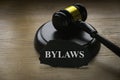 Bylaws phrase with gavel on wooden background. Business and law concept