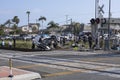Bystanders and police observe wreckage of vehicle hit by train in Oceanside