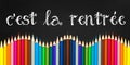 C`est la rentree meaning Back to school written on a black board background with a wave of colorful wooden pencils