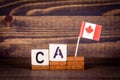 CA Canada. ISO standard - country abbreviation. Wooden letters and flag