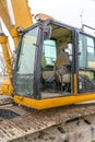 The cab and dirty grousers of a yellow excavator