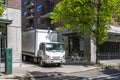 Cab over compact small rig semi truck with box trailer unloading goods standing on the urban city street with multilevel Royalty Free Stock Photo