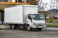 Cab over white compact semi truck with long box trailer deliver cargo to local business and unloading goods standing on the Royalty Free Stock Photo