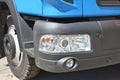 Cab, wheel and front black bumper with headlights, parking sensors and anti-fog lights of a blue truck Royalty Free Stock Photo
