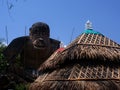 Cabana roof obscures the view of giant gorilla clay statue.