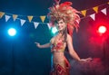 Cabaret, dancer and holidays concept - Cute young girl in bright colorful carnival costume on dark background Royalty Free Stock Photo