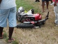 Motorcycle accident broken and wrecked lie on grass near road.
