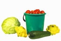 Cabbage, bucket with tomatoes, zucchini and squash on a white ba Royalty Free Stock Photo