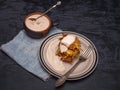 Cabbage oladi with sour cream lies on a dark wooden table, under the plate is a blue denim napkin