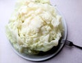 Cabbage prepared for making cabbage rolls on a plate with a fork, close-up, top view
