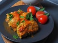 Cabbage rolls with meat, rice and vegetables. Stuffed Peking cabbage leaves with meat, in tomato sauce, on a black plate with Royalty Free Stock Photo