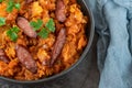 Cabbage stew in bowl with smoked sausages. Close up