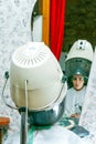 Hairdressing client with curlers on her head dries her hair in a retro dryer Royalty Free Stock Photo
