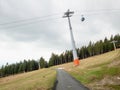 Cabin above grassy ski slope moving up to hill with tourist Royalty Free Stock Photo