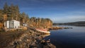 Cabin with boats and campervan by the lake in Lapland in Sweden in the sun with a blue sky