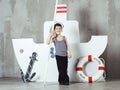 Cabin boy playing with paddle in front of stylized ship