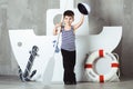 Cabin boy waving sailor cap in front of stylized ship