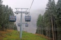 Cabin of Cable car lift arrive to top of the mountain with place of rest, restaurant and hotel in foggy day. Dolomites, Italy. Royalty Free Stock Photo