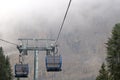 Cabin of Cable car lift arrive to top of the mountain with place of rest, restaurant and hotel in foggy day. Dolomites, Italy. Royalty Free Stock Photo