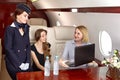 An air steward serves passengers inside the plane Royalty Free Stock Photo