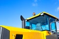 Cabin with flasher and exhaust pipe of road equipment against the blue sky, copy space, construction machinery