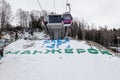 Cabin of a gondola cableway suspended on a rope in the Altai mountains with snow on winter. Ski resorts and snowboarding manzherok