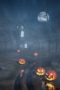 Cabin in a Halloween forest with pumpkin lanterns at night Royalty Free Stock Photo