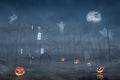 Cabin in a Halloween forest with pumpkin lanterns at night Royalty Free Stock Photo