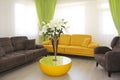 Cabin interior with yellow and brown sofas and white lilies