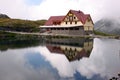Cabin on a lake, with reflections in the water. Royalty Free Stock Photo